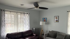 A living room with a brown leather sofa, a grey sofa, a floor lamp, and two framed pictures on the wall. - Roomy 2 Bedroom Apartment 20 Minutes from Philadelphia (glenolden)