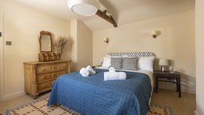 A bedroom with a bed, a dresser, a mirror, and two bedside tables with lamps. - Horseshoe Cottage - sleeps 4 guests  in 2 bedrooms (Oxfordshire)