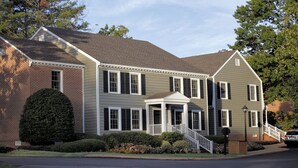 A two-story house with a front porch, a covered entryway, and a brick section on the left. - Quaint studio near historic Colonial Williamsburg (Williamsburg)