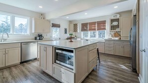 A spacious kitchen with a central island, built-in oven, and ample counter space. - Lakefront Luxury - Boat Slip - Kayaks - Game Room (Waleska)