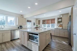 A spacious kitchen with a central island, built-in oven, and ample counter space. - Lakefront Luxury - Boat Slip - Kayaks - Game Room (Waleska)