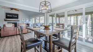 A spacious dining area with a large table, comfortable seating, and a view of the outdoors through large windows. - Lakefront Luxury - Boat Slip - Kayaks - Game Room (Waleska)
