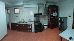 Una cocina compacta con estufa, lavabo y armarios.