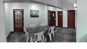 Un comedor con una mesa y sillas, un cartel en la pared y un suelo estampado.