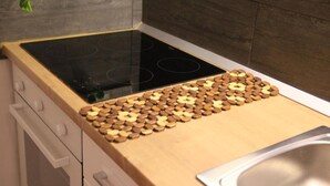 Eine Küche mit modernem Herd, Schneidebrett aus Holz und Spüle aus Edelstahl.