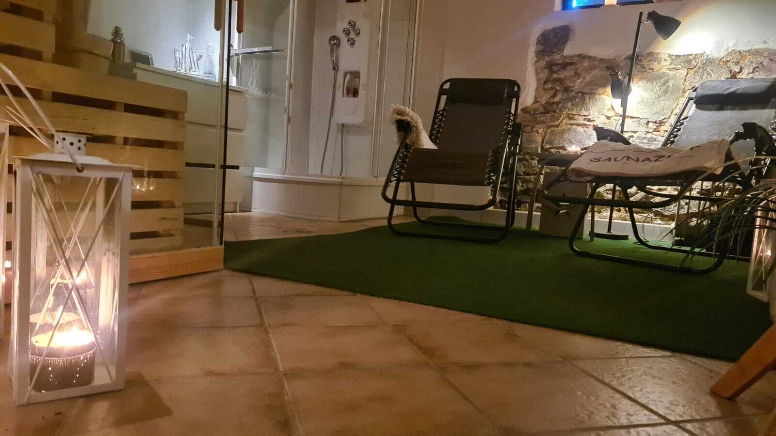 A room with a green carpet, a wooden bench, a metal chair, and a small table.