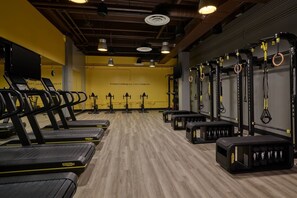 Ein Fitnessstudio mit Laufbändern, Kraftgeräten und Widerstandsbändern.