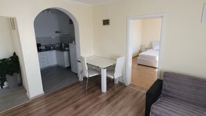 Un espacio habitable compacto con kitchenette, comedor y dormitorio.