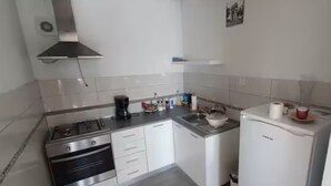 Una cocina moderna con electrodomésticos de acero inoxidable, armarios blancos y salpicadero de azulejos.