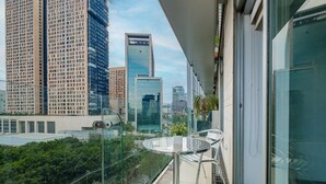 A balcony with a glass railing, a round table, and two chairs. - 2BR Luxury Stay Mundial 2026 Skyline Views (Mexico City)
