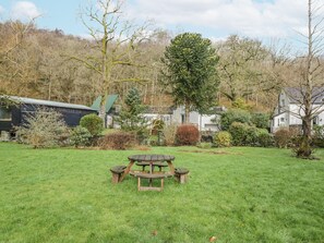 A picnic table in a grassy area with houses and trees in the background. - The Dove Cot (Ambleside)