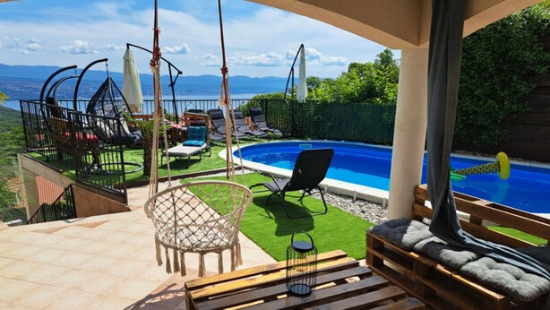 A covered outdoor area with a pool, seating, and a view of the mountains. - Beautiful Unique Family Villa Emily (Opatija)