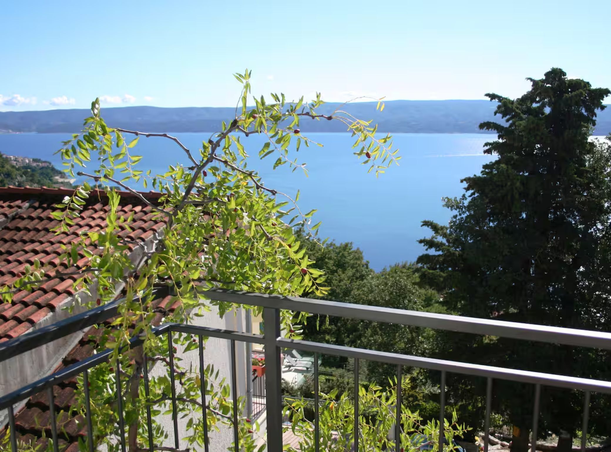 Un balcon donnant sur un lac et sur des collines lointaines.