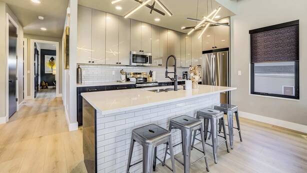 A modern kitchen with a large island, stainless steel appliances, and bar stools. - The Gallery! Luxury Residence w/ Front Range Views (Monument)