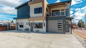 A modern two-story house with a garage, a balcony, and a patio area. - The Gallery! Luxury Residence w/ Front Range Views (Monument)