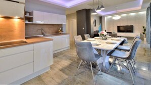 A modern kitchen with white cabinets, a wooden countertop, and pendant lighting. - Villa Marija Exclusive Stay (Sukosan)