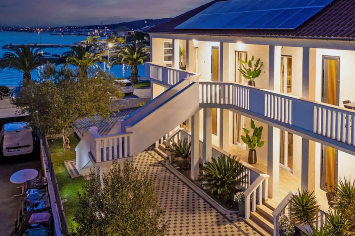 Un bâtiment moderne avec un escalier menant à un balcon d’où l’on a vue sur une étendue d’eau.