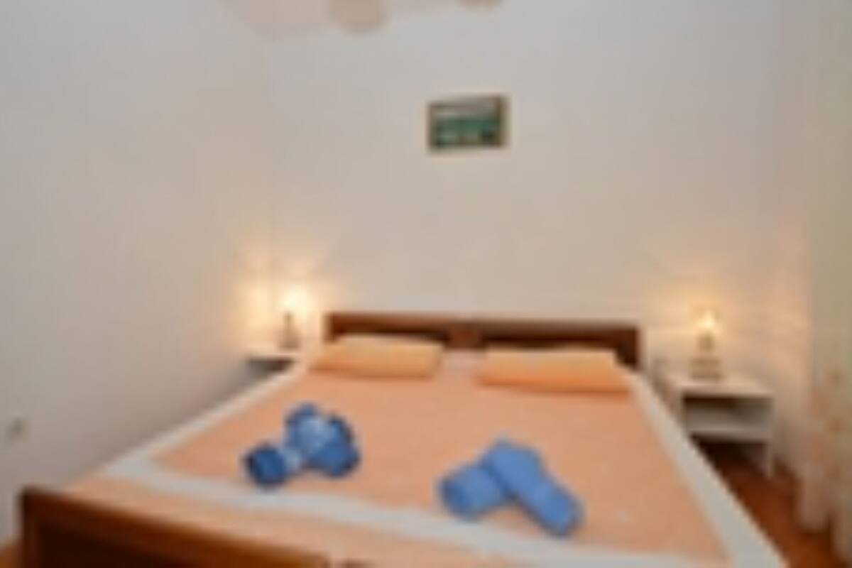 Un dormitorio con cama, almohadas y lámparas de noche.