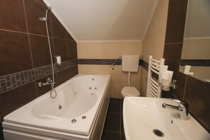 Un baño con bañera, lavamanos e inodoro.
