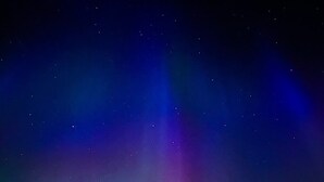 A tent under a night sky with visible stars and aurora borealis. - Nomad Greenland (Saqqaq)