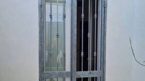Ein Fenster mit Metallgitter und Glasscheibe.