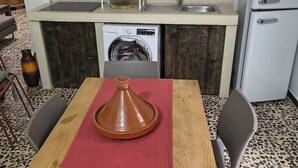 Eine kleine Küche mit Mikrowelle, Waschmaschine und Kühlschrank.