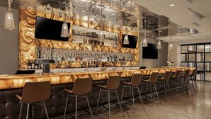 Eine moderne Bar mit einer Marmorplatte, mehreren Barhocker und einer Auswahl an Spirituosenflaschen.