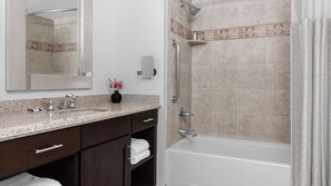 A bathroom with a sink, mirror, towel rack, and shower with grab bars. - Right on the strip no resort fees (Las Vegas)