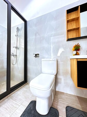 Een douche, handdoeken, zeep, toiletpapier