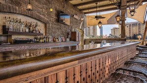 Eine Bar mit einer Holztresen und Regalen voller Spirituosenflaschen.