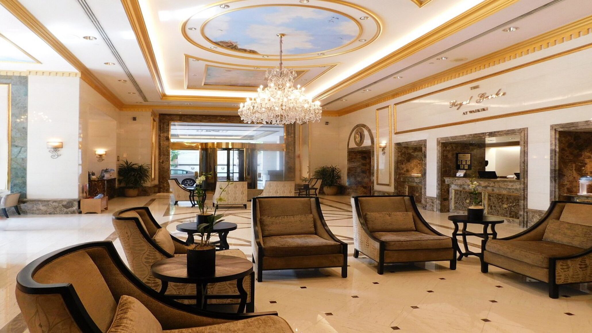 Eine geräumige Lobby mit einem Chandelier, gemütlicher Sitzgelegenheiten und einer Rezeption.
