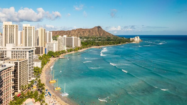 A coastal cityscape with high-rise buildings, a beach, and a mountain in the background. - Asian inspired decor in this beautiful studio (Honolulu)