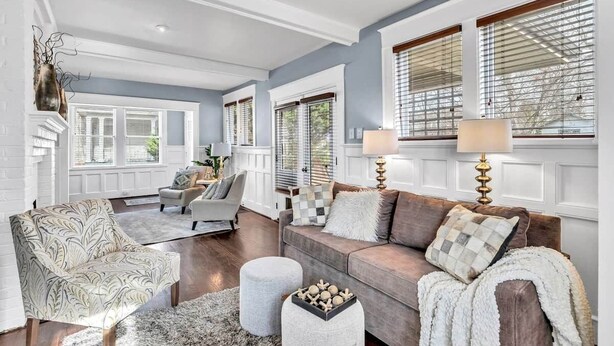 A living room with a sofa, armchairs, a rug, and a coffee table. - Historic Home with King Bed (High Point)