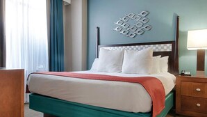 A hotel room with a bed, a nightstand, a lamp, and a decorative wall piece. - 3 bdrm near Gaylord Palms (Oxon Hill)