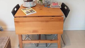 Une table en bois, une lampe, un bol et un magazine.