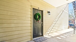 A house with a dark door, a green wreath, and a welcome mat.