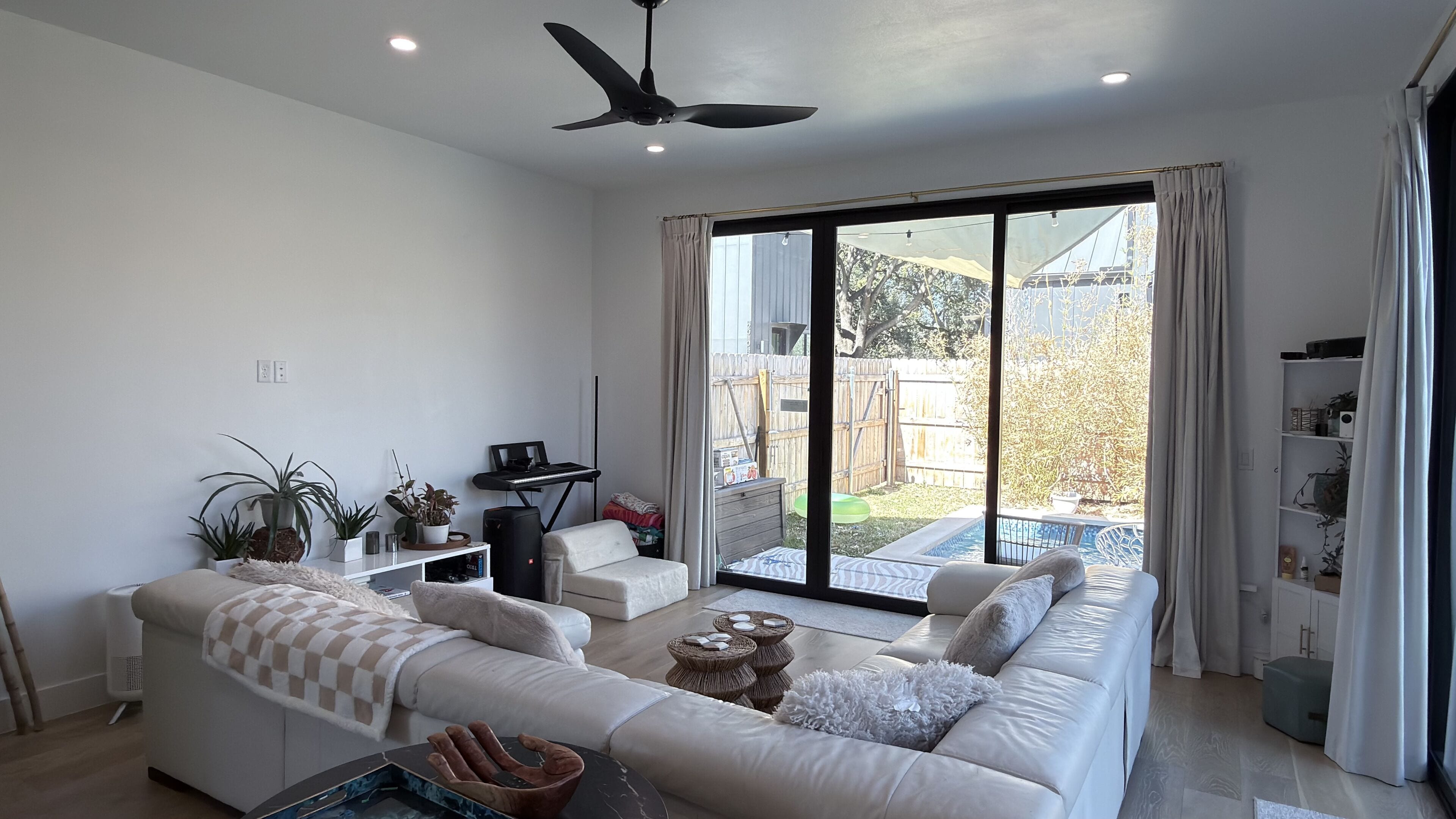 A modern living room with a sofa, coffee table, and a ceiling fan.