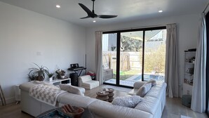 Una sala moderna con un sofá, una mesa de centro y un ventilador de techo.