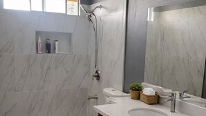 A modern bathroom with a shower, toilet, and dual sinks. - Spacious 4BR Norco Retreat; Near SilverLakes; Pet Friendly; RV Parking (Norco)