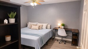 A bedroom with a bed, a desk, a chair, a ceiling fan, and a bookshelf. - Spacious 4BR Norco Retreat; Near SilverLakes; Pet Friendly; RV Parking (Norco)
