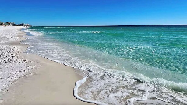 Una playa con agua turquesa cristalina y una orilla arenosa.