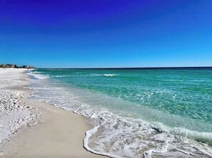 Ein Strand mit klarem türkisblauem Wasser und einem sandigen Ufer.