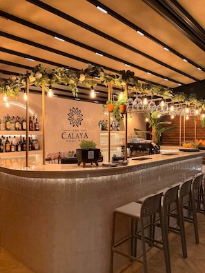 A bar area with a counter, bar stools, hanging plants, and a sign reading 'The Calaya Pool Bar'. - "Sienna" – Adults Only (+16) (Sarandë)