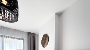 A modern living room with a large TV, a sofa, a chair, and a window with curtains. - "Gold" – Adults Only (+16) (Sarandë)