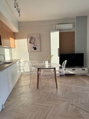 A modern living room with a dining area, a kitchen, and a TV. - Valentina - Corfu View Residence (Sarandë)