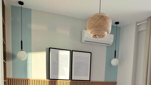 A modern bedroom with a wooden headboard, a large bed with a grey blanket, two bedside tables, and a hanging rattan lamp. - Valerie - Corfu View Residence (Sarandë)