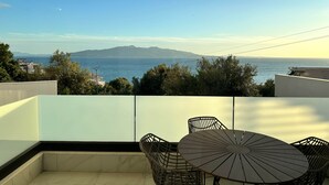 A balcony with a table and chairs, overlooking a sea view with distant mountains. - Valerie - Corfu View Residence (Sarandë)