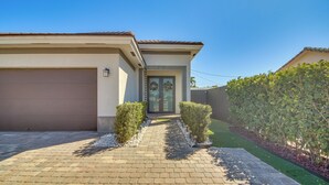 Une maison d’habitation avec une allée pavée, un garage et une pelouse bien entretenue.
