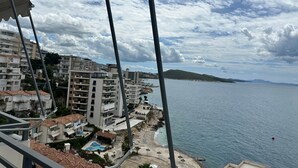 Zona residencial costera con edificios de varios pisos, una playa y una vista despejada del mar.