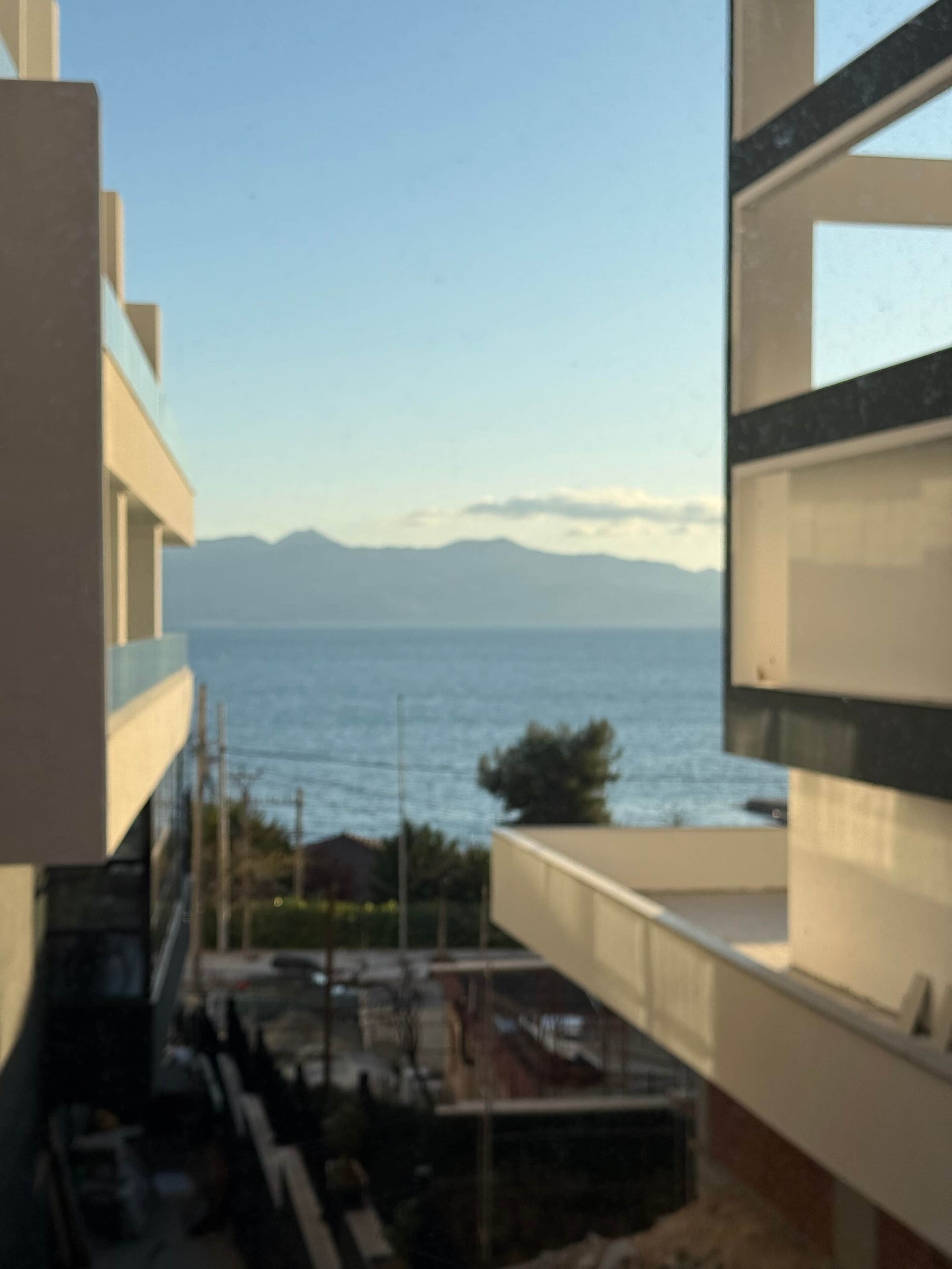 A view from a balcony overlooking a body of water with mountains in the distance.